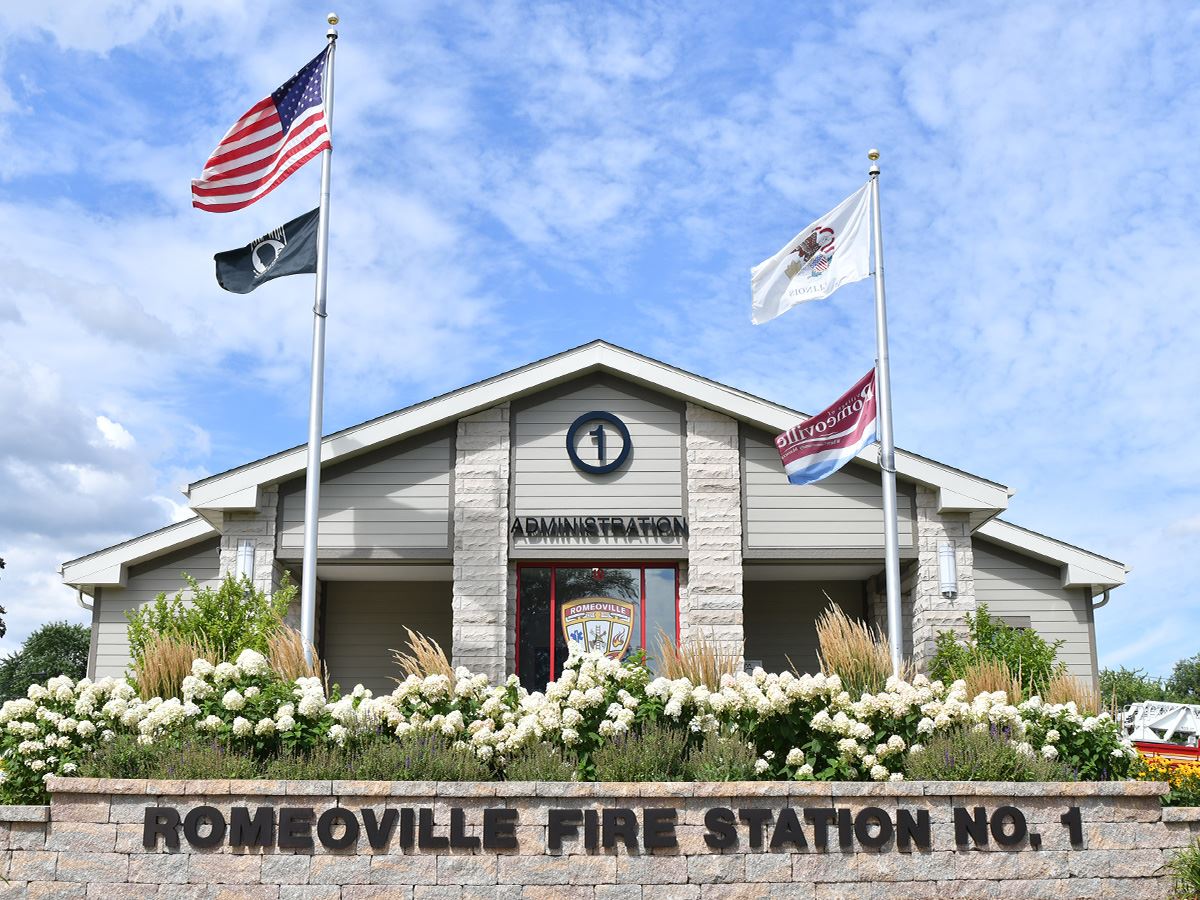 Fire Station 1 with flags, flower bed, and decorative bricks.